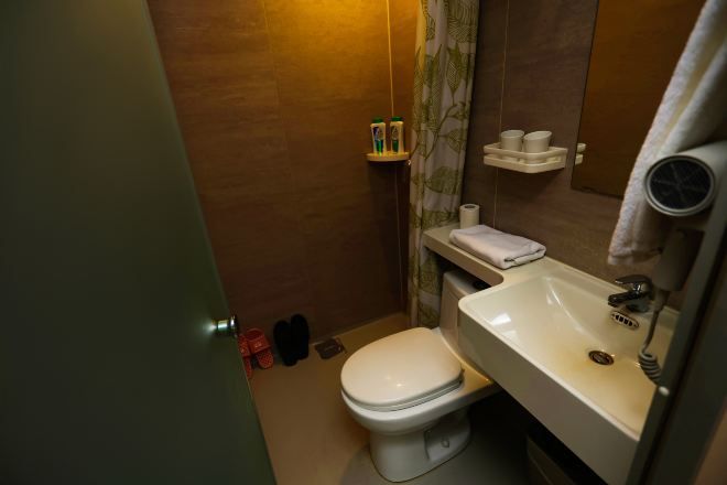 A compact bathroom with a toilet, sink, and a mirror.