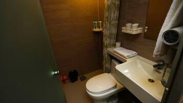 A compact bathroom with a toilet, sink, and a mirror.