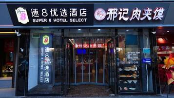 The exterior of a hotel with a glass entrance and signage indicating it is a Super 8 hotel.