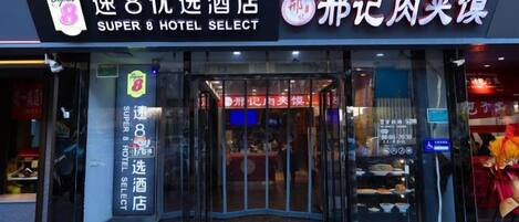 L’extérieur d’un hôtel doté d’une entrée en verre et d’une enseigne indiquant qu’il s’agit d’un hôtel Super 8.