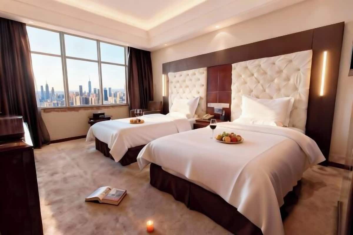 A hotel room with two beds, a city view, and a modern design.