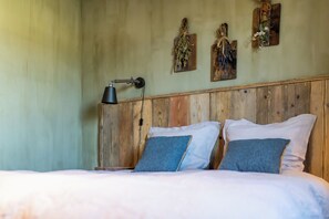 Cozy retreat with a wooden headboard, comfortable bed, and a desk lamp.
