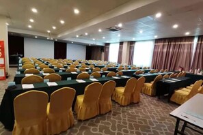 A conference room with rows of tables and chairs, equipped with microphones and papers, suggesting a meeting or event setup. - Sea Trek Star Exquisite Hotel (Lishui)