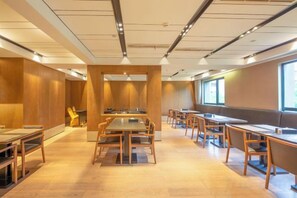 A conference room with multiple tables and chairs, wooden panel walls, and large windows. - Sea Trek Star Exquisite Hotel (Lishui)