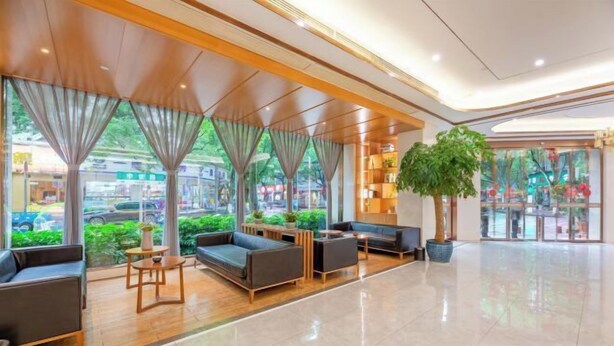 A spacious lobby with a modern design, featuring a seating area with sofas and tables, large windows with curtains, and a large indoor plant. - Sea Trek Star Exquisite Hotel (Lishui)