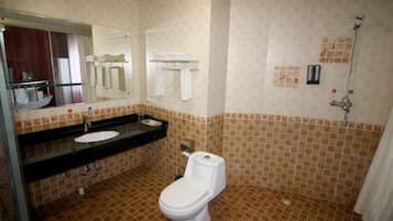 Un baño con inodoro, lavabo y ducha.