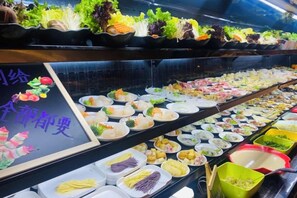 A buffet with various food items and a sign with text. - Shuiyi Boqing Hotel (Heze)