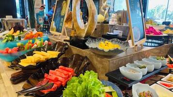 A buffet with various food items and a large decorative sculpture.
