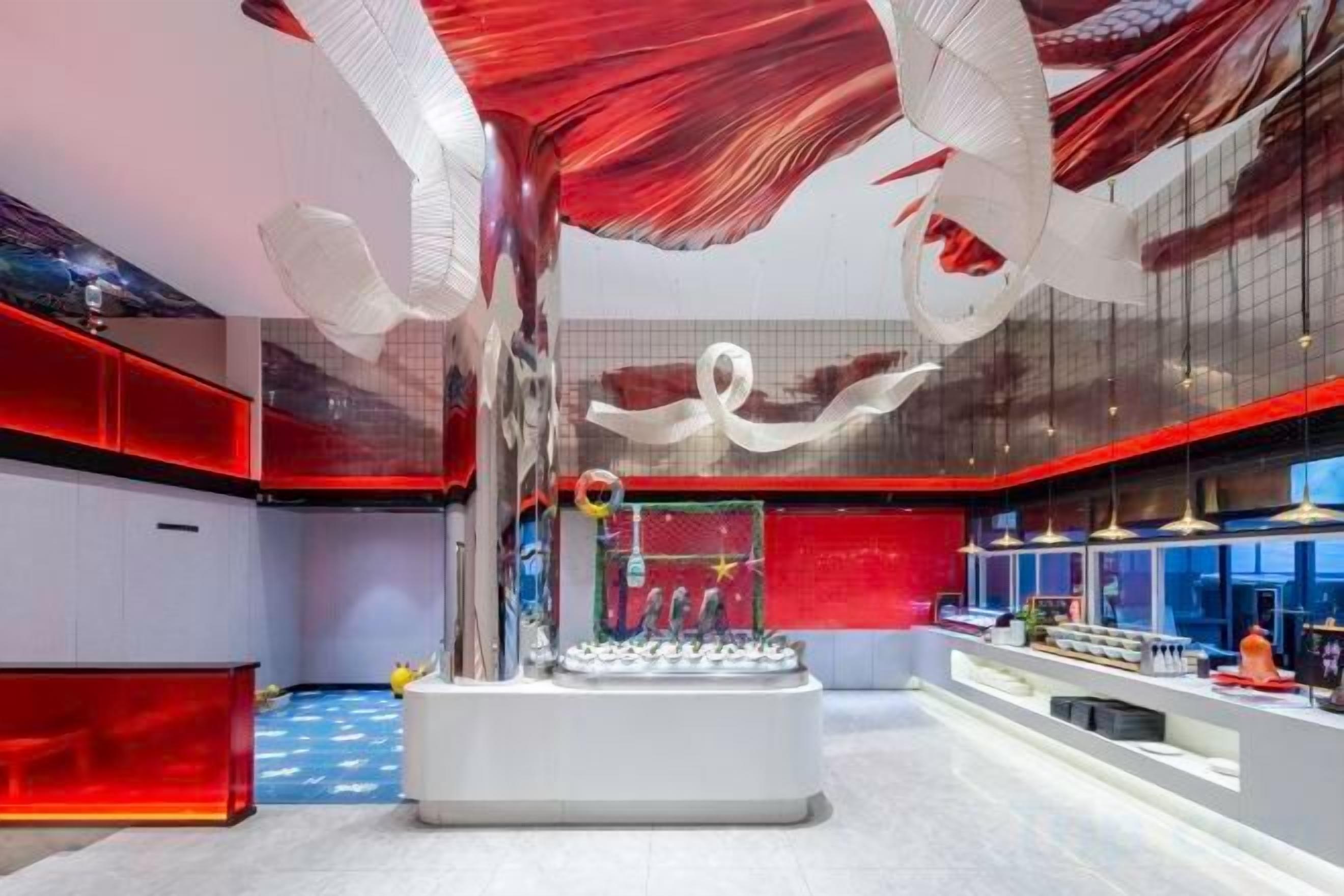 A modern interior with a central white structure, red accents, and a glass ceiling.