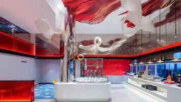 A modern interior with a central white structure, red accents, and a glass ceiling.