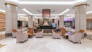 A spacious lobby with marble flooring, a central fountain, and seating areas. - Shuiyi Boqing Hotel (Heze)