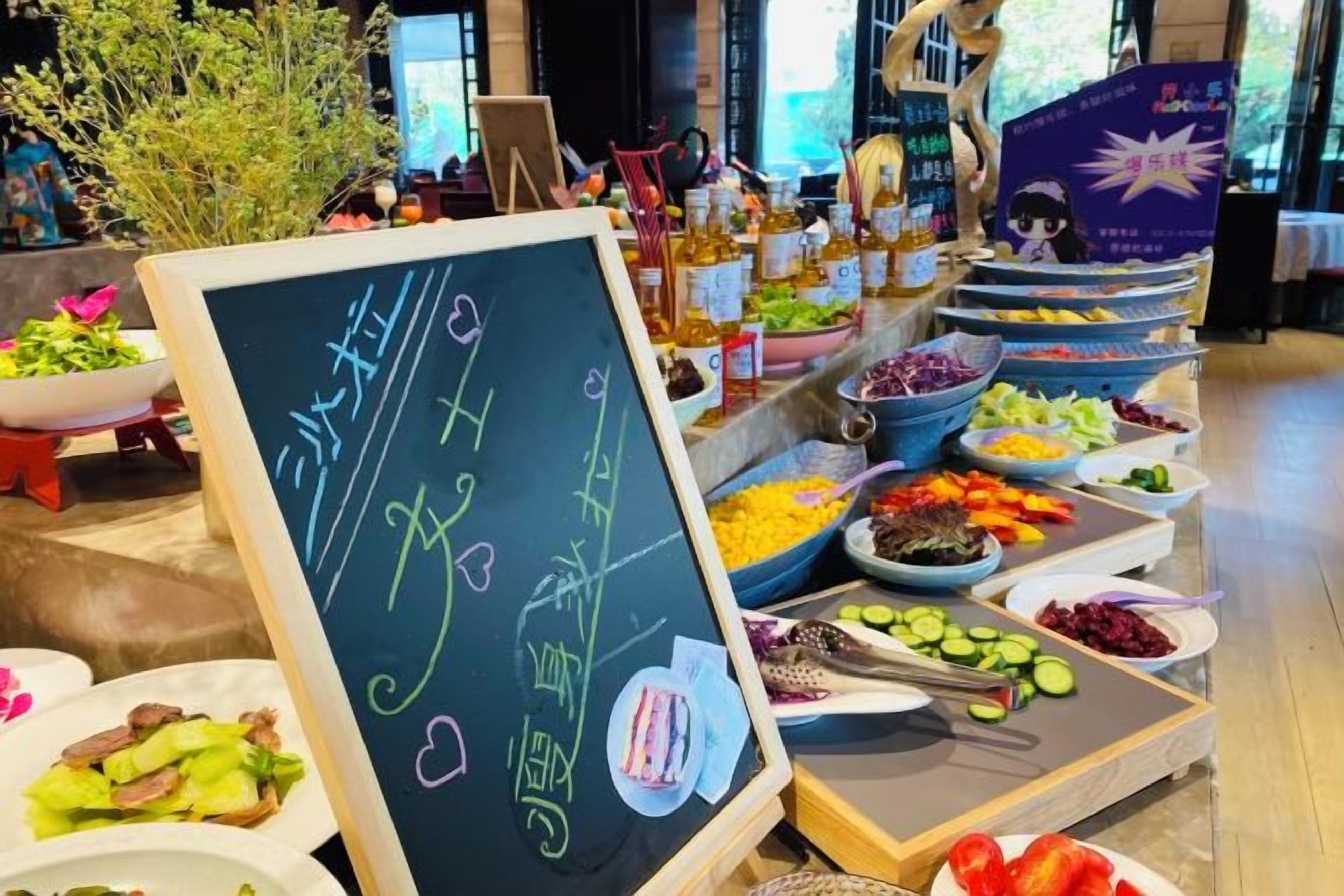 A buffet with various food items and a chalkboard with text.