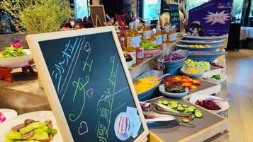 A buffet with various food items and a chalkboard with text.