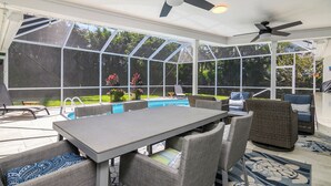 A sunroom with a pool, outdoor furniture, and ceiling fans. - Your vacation home away from home (Naples)