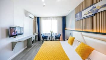Habitación de hotel con cama, televisión, escritorio y silla.