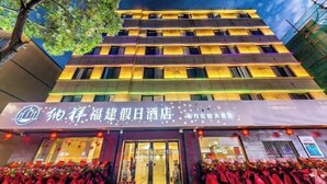 A hotel with multiple floors, a prominent entrance with glass doors, and a row of tables outside covered with red tablecloths. - Naxiang Fujian Holiday Inn (Zhujiajian branch of Oriental Garden Hotel) (Zhoushan)