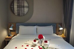 A hotel room with a neatly made bed, two bedside lamps, and a wall-mounted light fixture. - Homeinn Hotel (Dalian People's Square Xinkai Road) (Dalian)