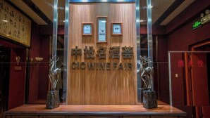 A wooden reception desk with the text "CICWINEFAR" and two animal statues. - Homeinn Hotel (Dalian People's Square Xinkai Road) (Dalian)
