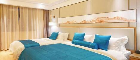 Una habitación de hotel con una cama grande, un cabecero con un cuadro y una mesita de noche.