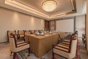 A conference room with a long table, chairs, and a chandelier. - Qingdao Huaxi Hotel (Qingdao)