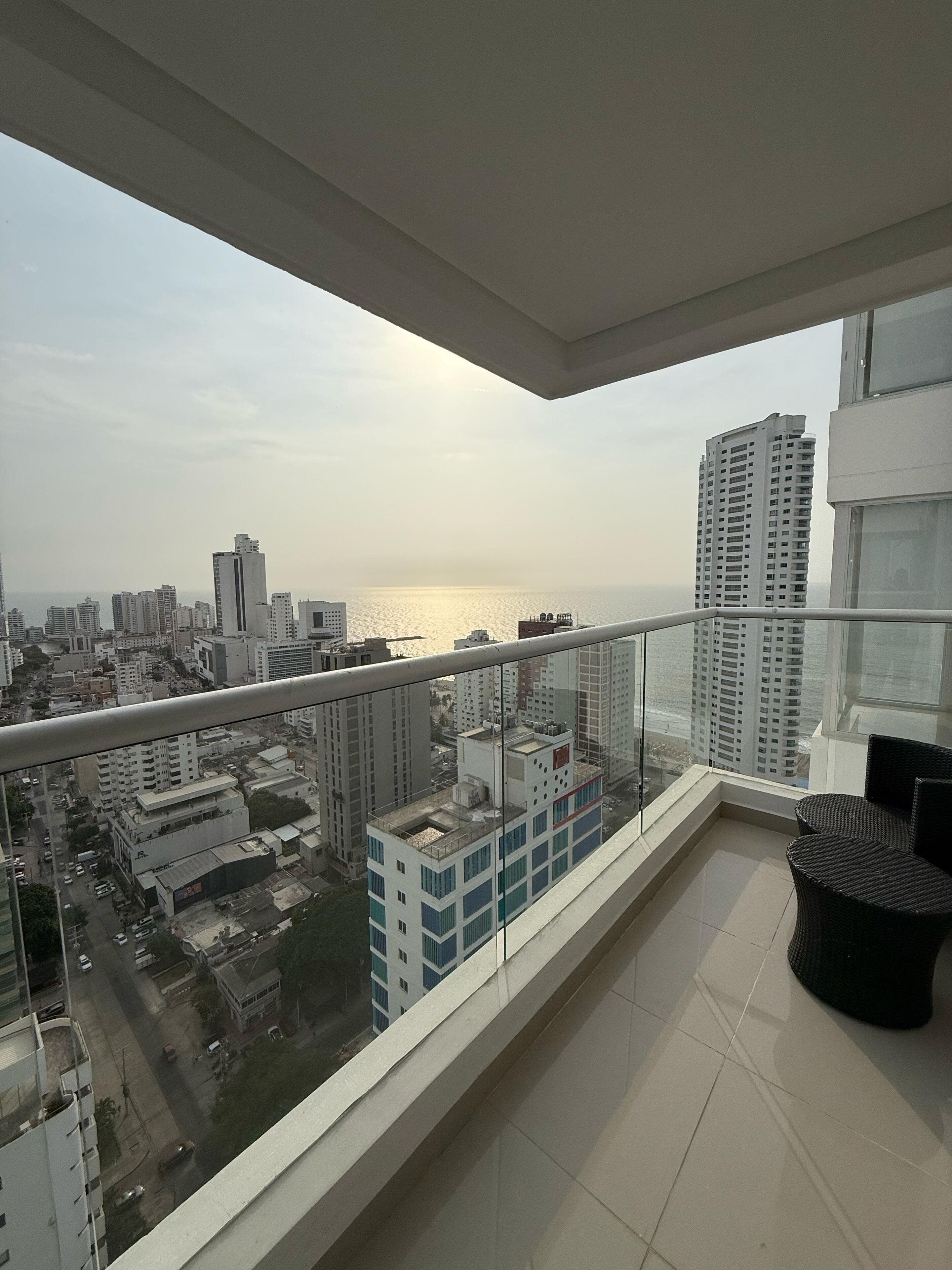 Ein Balkon mit Blick auf eine Stadtlandschaft und ein Gewässer.