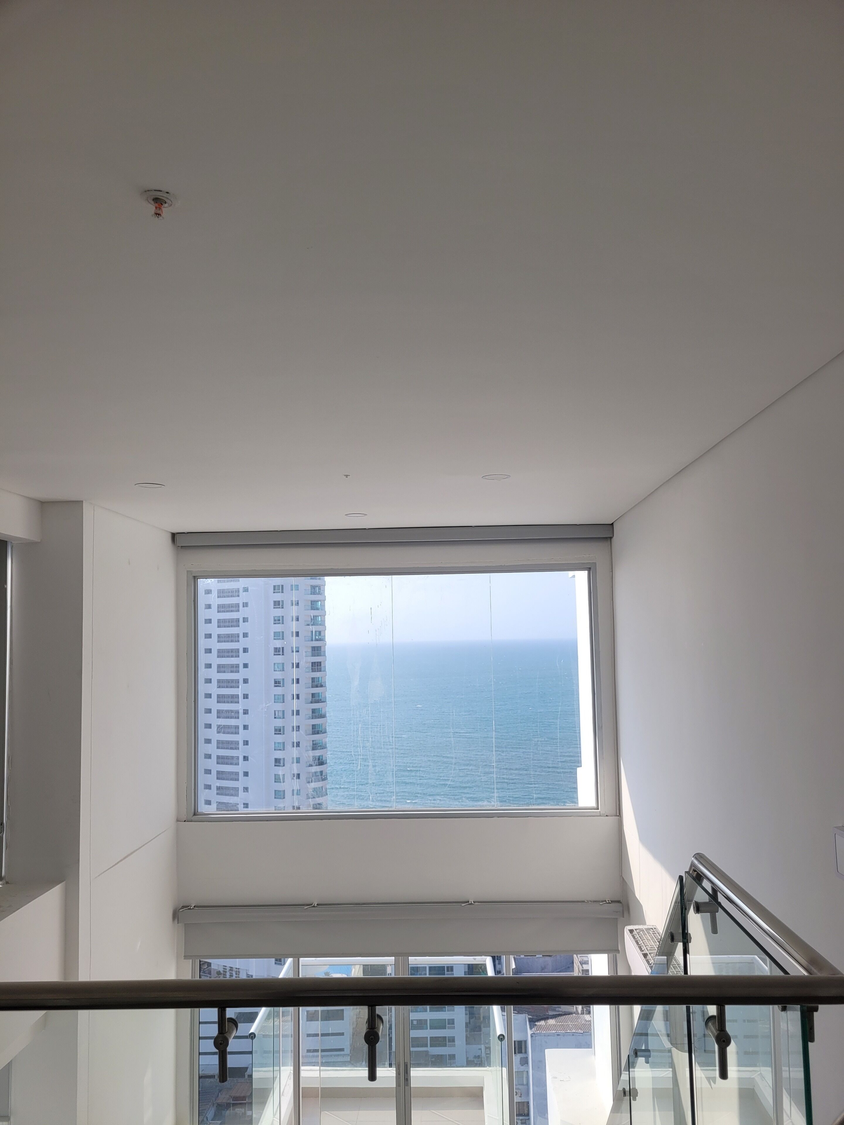 Un appartement situé dans un immeuble de grande hauteur, doté d’une grande fenêtre donnant sur l’océan.