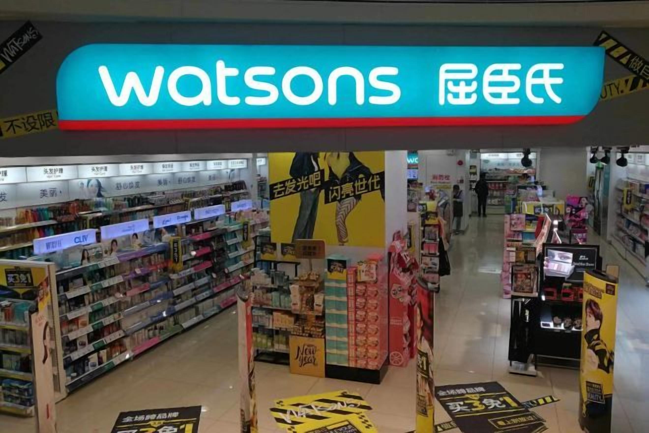 Ein Supermarktfass mit einem gut sichtbaren 'Watsons'-Schild, Regalen voller Ware und Werbeaktionen.