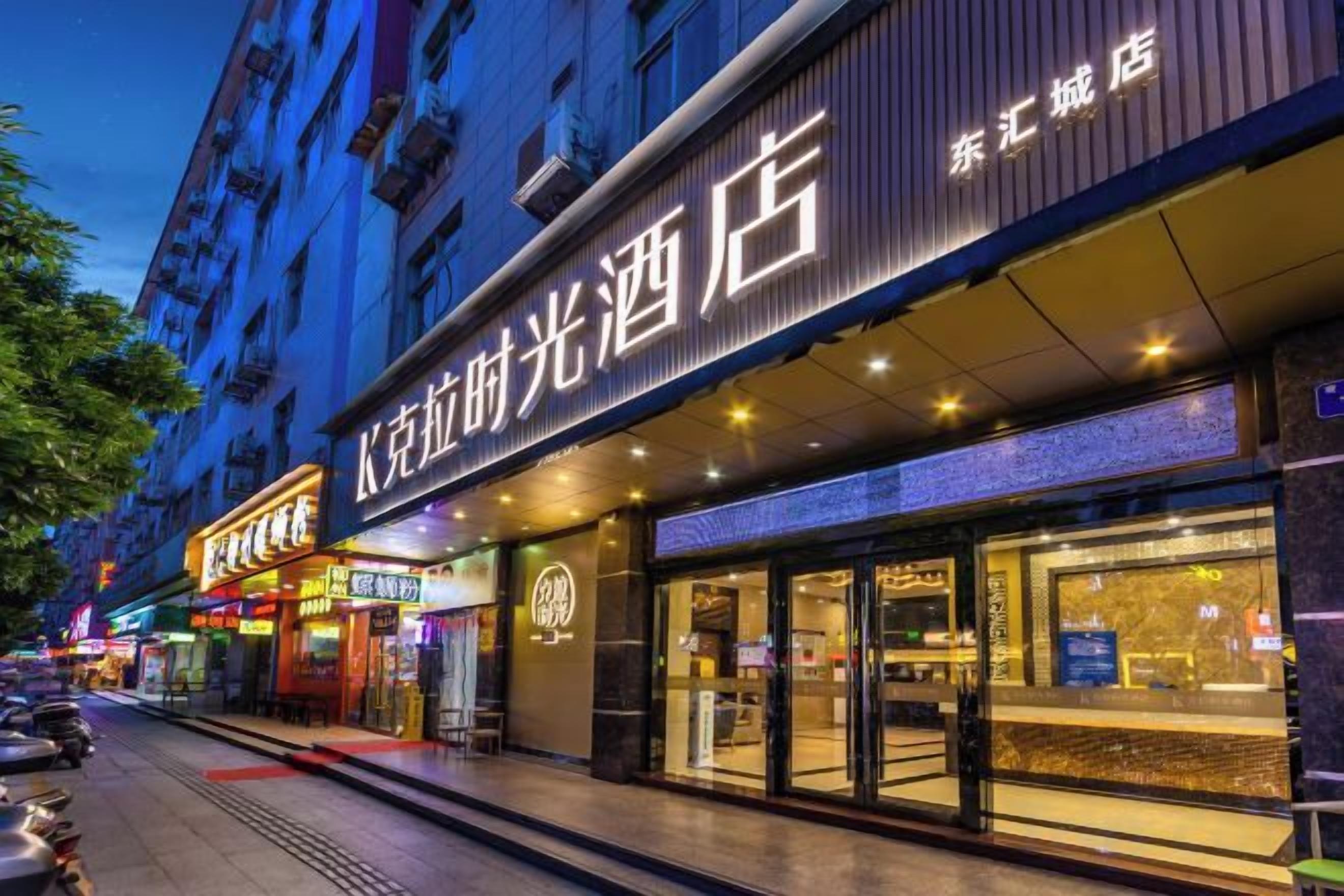A hotel with a prominent sign, a storefront, and a visible entrance.