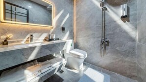 Une salle de bain moderne avec un lavabo en marbre, des toilettes et une douche.