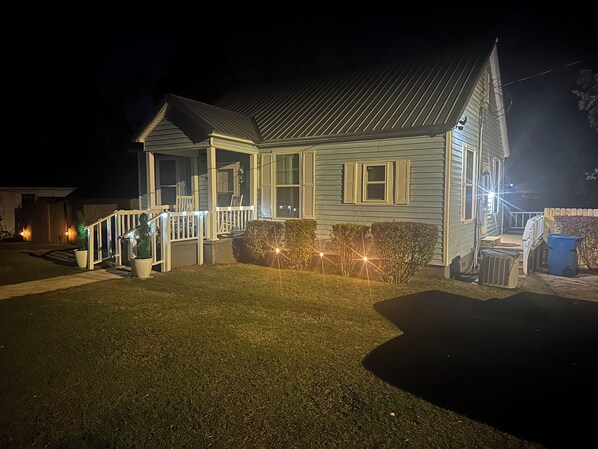 A two-story house with a porch and a small front yard. - Charming 2-bedroom house in Monroeville with Wi-Fi and AC. (Monroeville)
