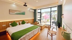 A hotel room with a bed, a desk, a chair, a window with a view, and a ceiling projector. - Zhouzhuang Jingou Linhe Bieyuan Chinese Inn (Kunshan)