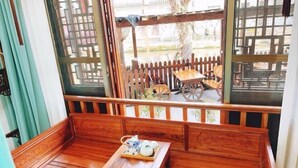 A wooden bench with a tray of teaware, a wooden table, and a view of a wooden fence and cart outside. - Zhouzhuang Jingou Linhe Bieyuan Chinese Inn (Kunshan)