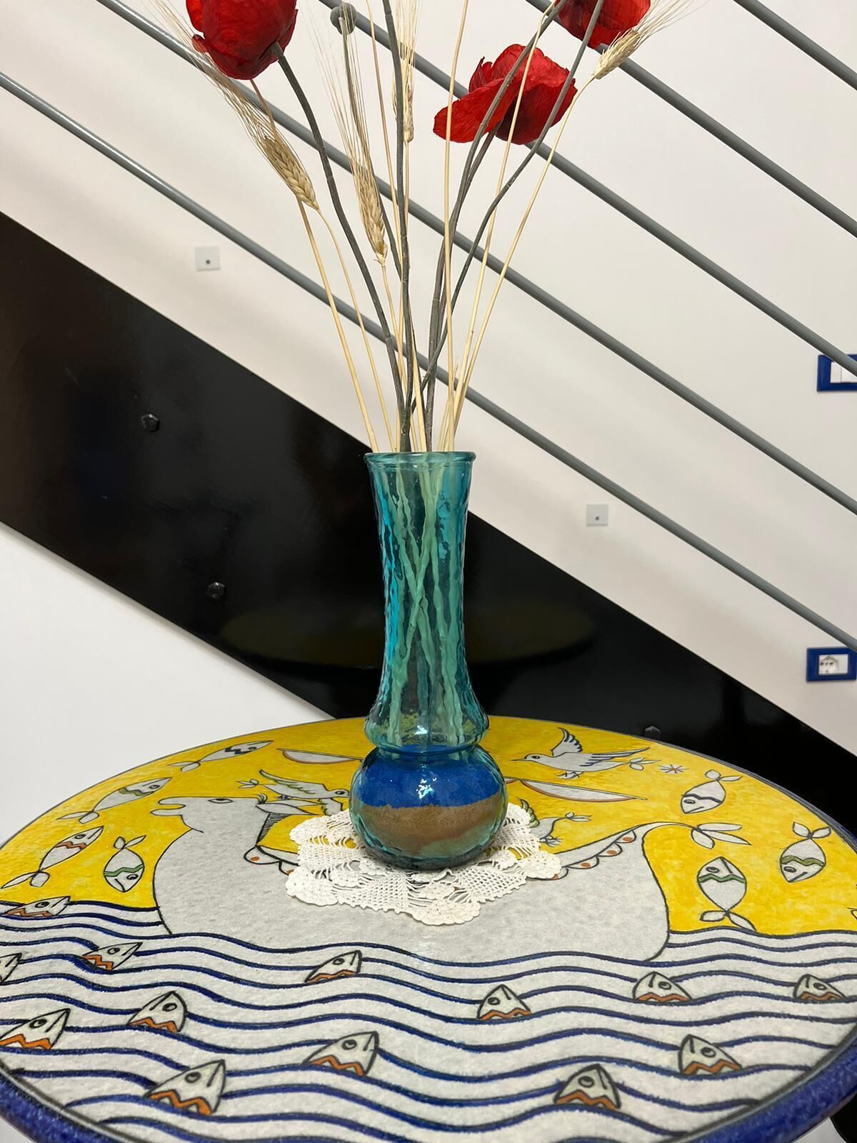 A vase with dried plants on a decorative table.