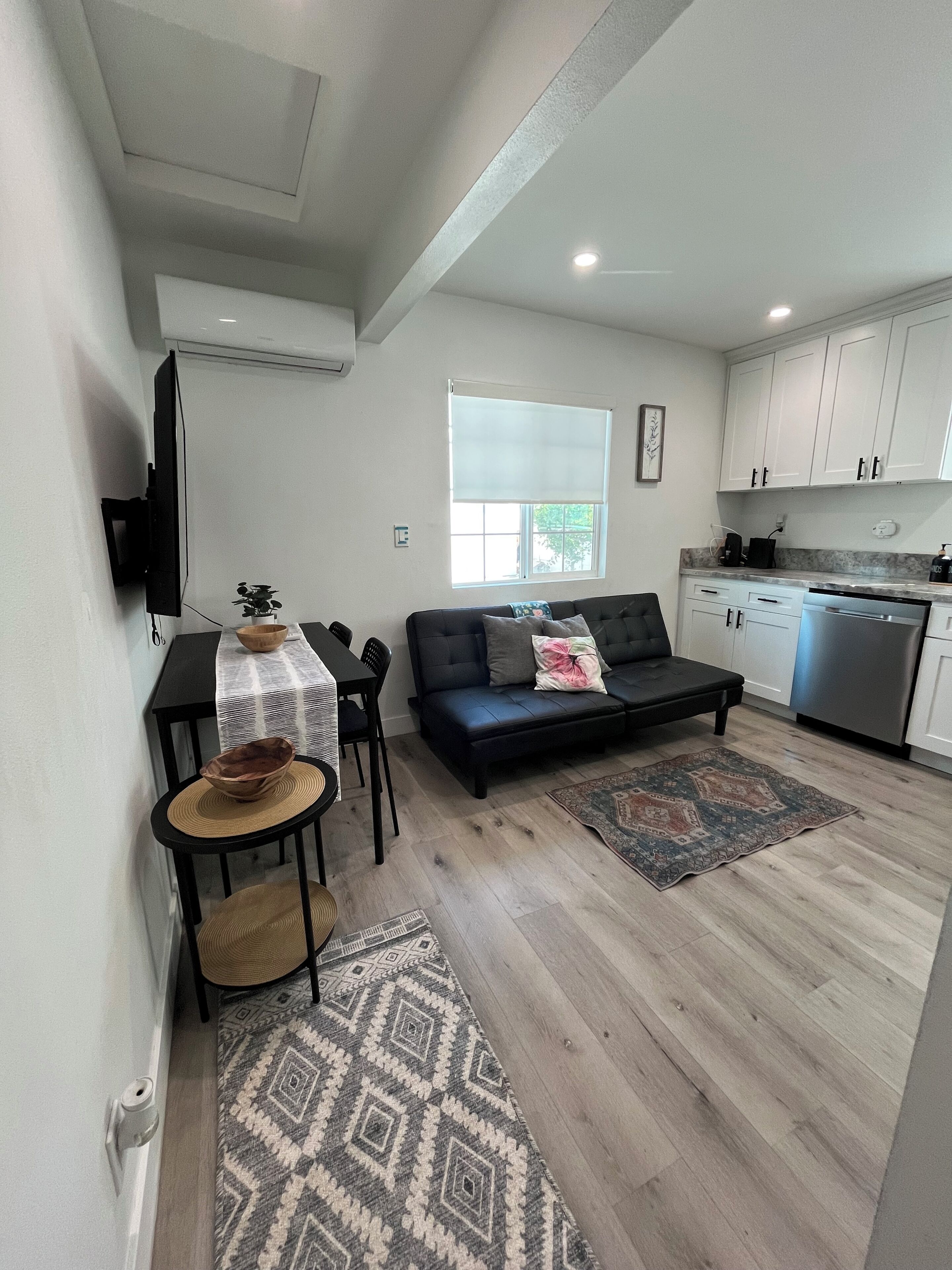 A compact living space with a sofa, dining table, and kitchen area.