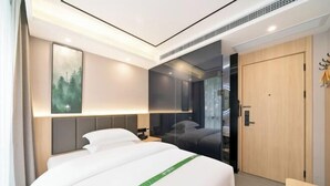 A modern hotel room with a large bed, a mirror, a wooden door, and a view of the outdoors. - GreenTree Inn Express (Shanghai City God's Temple BundYu Garden subway station shop) (Shanghai)