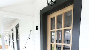 A front door with a wooden panel, a black mailbox, and a doormat with the word 'hi'. - Walkable Outdoor Oasis BBQ Firepit and Bocce Ball (Tampa)