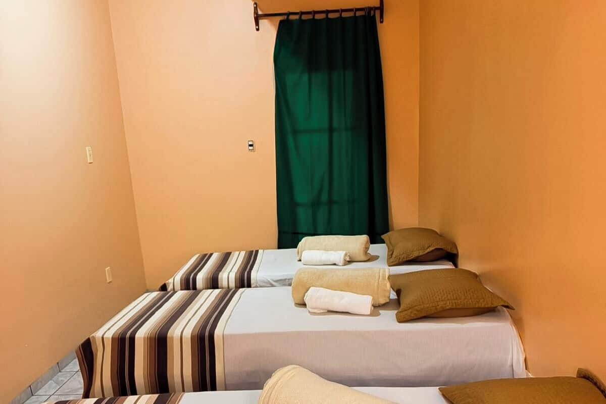 Ein Hotelzimmer mit zwei Betten, jeweils mit gestreifter Bettwäsche und Kissen.
