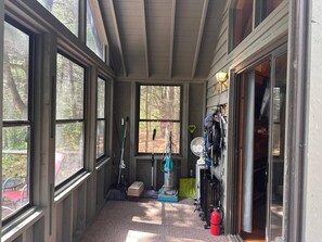 A room with large windows, a vacuum cleaner, a fan, and a red bucket. - Woodsy and Private- Rustic Cabin (Paradise)