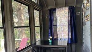 A room with a table and chairs, large windows, and a view of trees outside. - Woodsy and Private- Rustic Cabin (Paradise)
