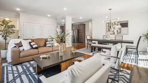 A modern living room with a sofa, coffee table, and dining area. - Saddle Ridge at Kearny - Luxury 4-Bedroom Oasis (Kearny)