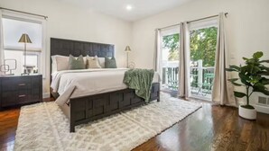 A bedroom with a bed, bedside tables, a large window, and a view of the outdoors. - Saddle Ridge at Kearny - Luxury 4-Bedroom Oasis (Kearny)