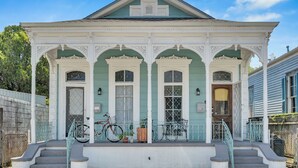 A two-story house with a porch, a bicycle, and a mailbox.
