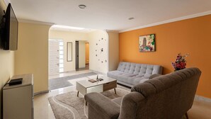 A living room with a sofa, coffee table, and a flat-screen TV. - Family house in the north of Bogota (Bogotá, D.C.)