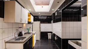 A modern kitchen with a skylight, black and white tiled walls, and a central island. - Family house in the north of Bogota (Bogotá, D.C.)