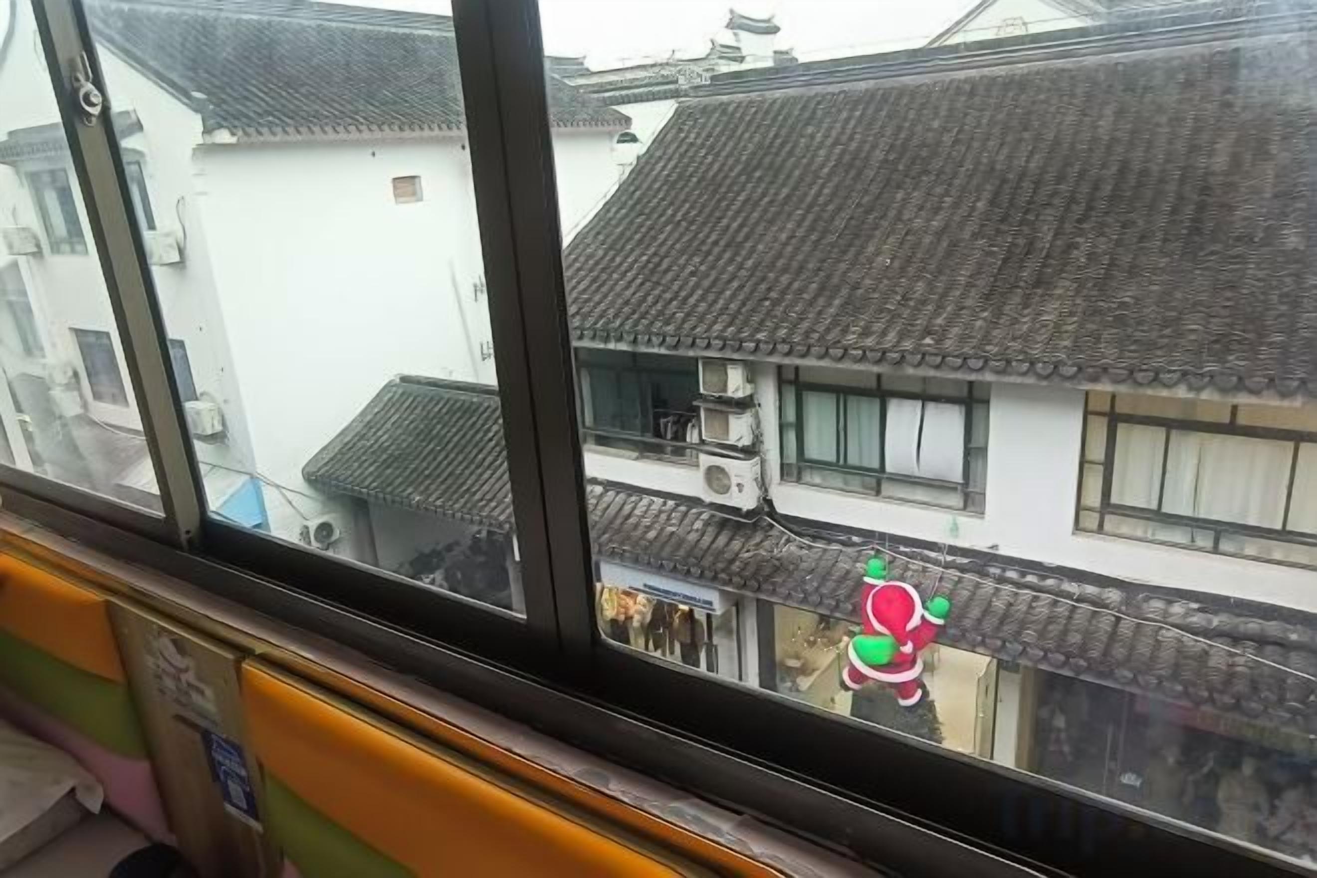 A view through a window with traditional tiled roofs and buildings.