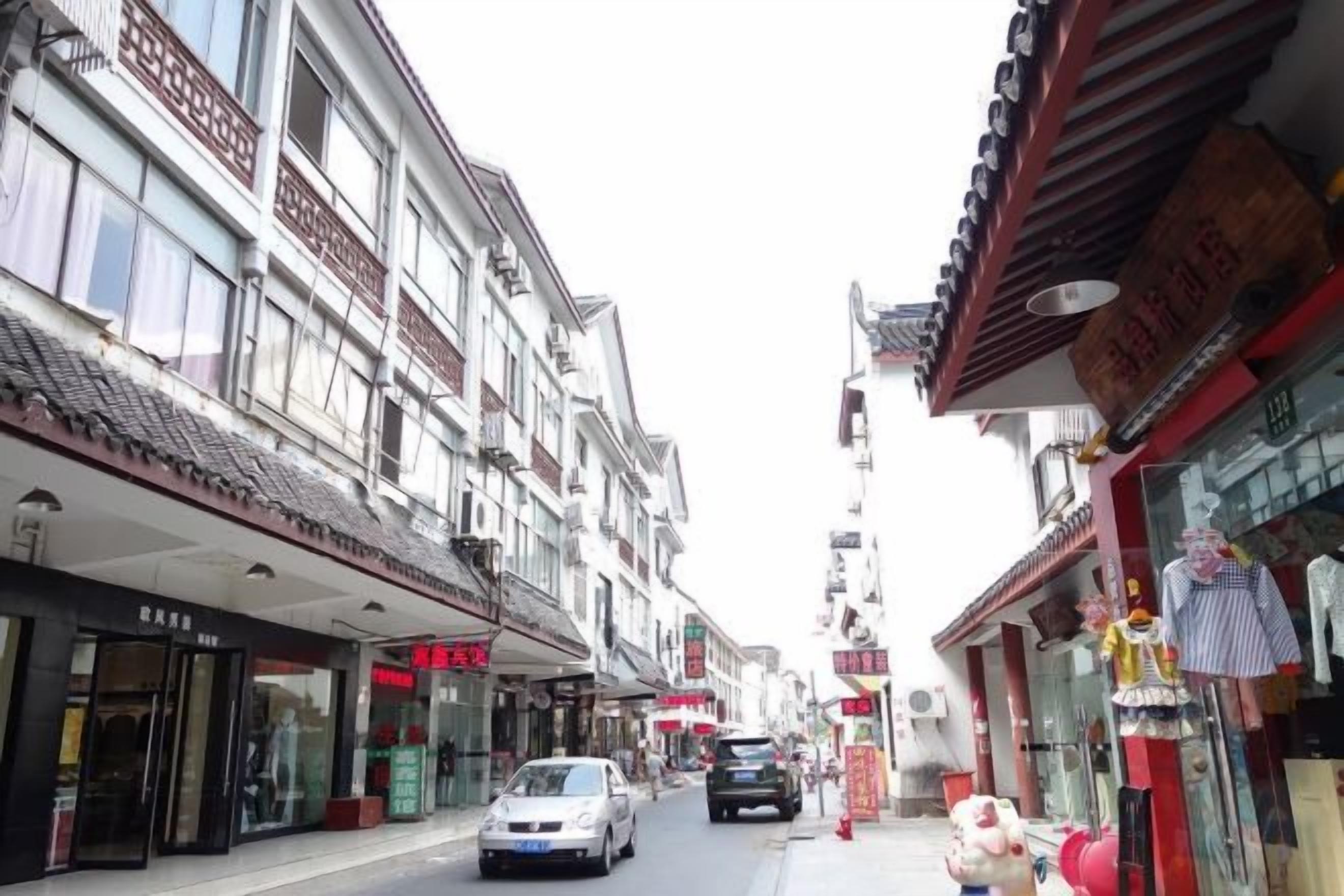 A narrow street lined with traditional buildings, some with visible signage and storefronts.