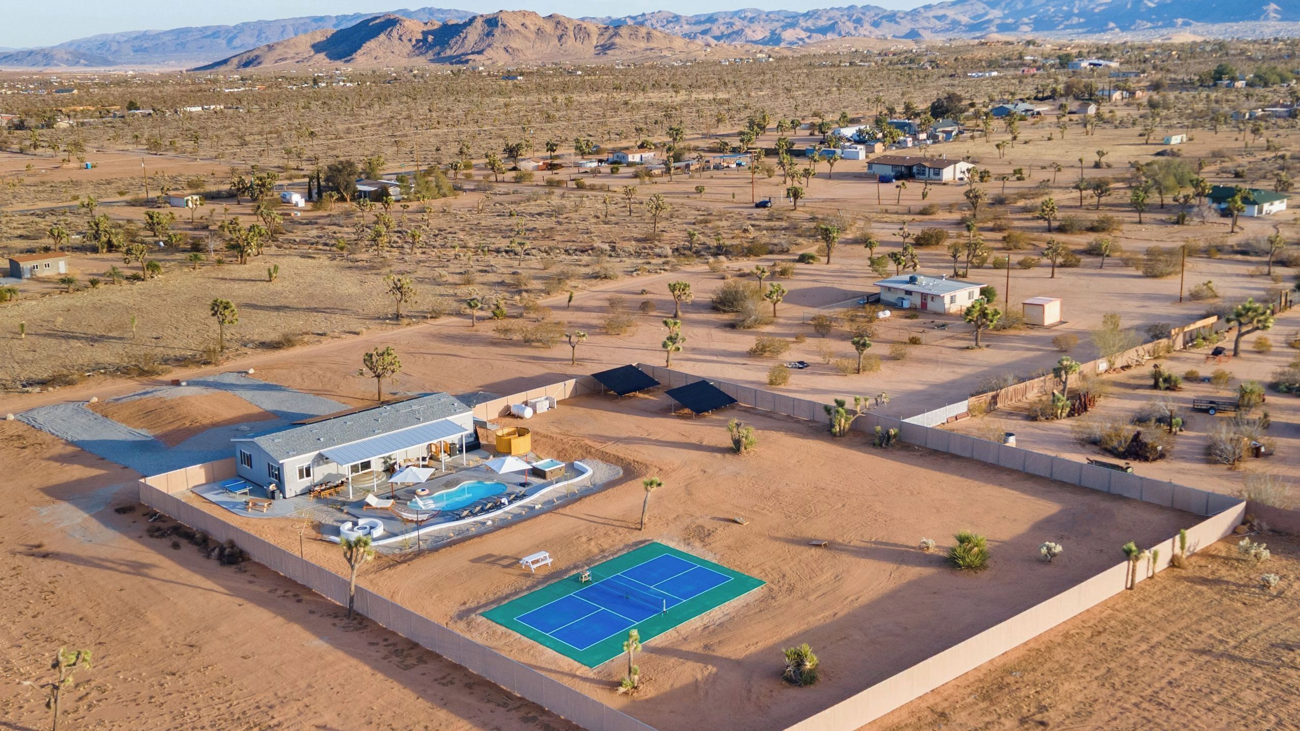 Et ørkenresort med tennisbane, pool og flere værelser.