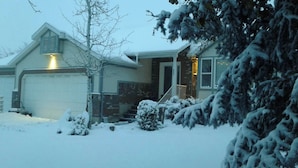 A residential house with a garage, a covered porch, and snow-covered trees. - 2 story, private, quiet upscale neighborhood MINUTES FROM 4 MAJOR SKI RESORTS (West Jordan)