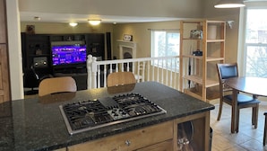 A kitchen with a gas stove, wooden cabinets, and a dining area with a table and chairs. - 2 story, private, quiet upscale neighborhood MINUTES FROM 4 MAJOR SKI RESORTS (West Jordan)