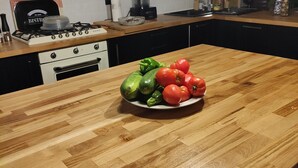Uma cozinha com bancada de madeira, fogão e parede de tijolos.